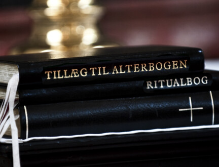 Ritualbogen, alterbogen og bibelen ligger oven på hinanden på et alter.